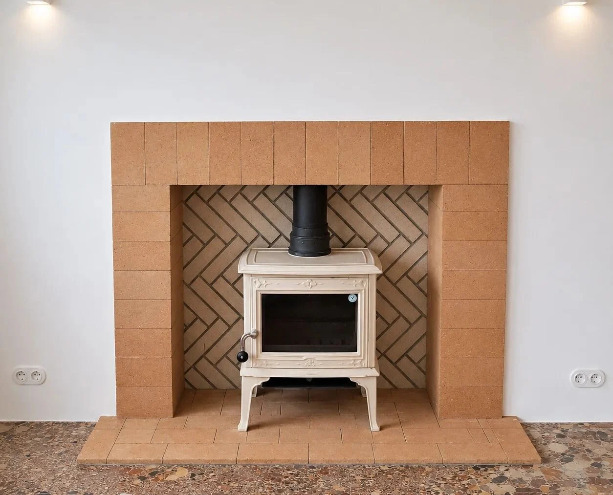 After — dressed stone fireplace, with a brick firebox laid in herringbone over encaustic tiles