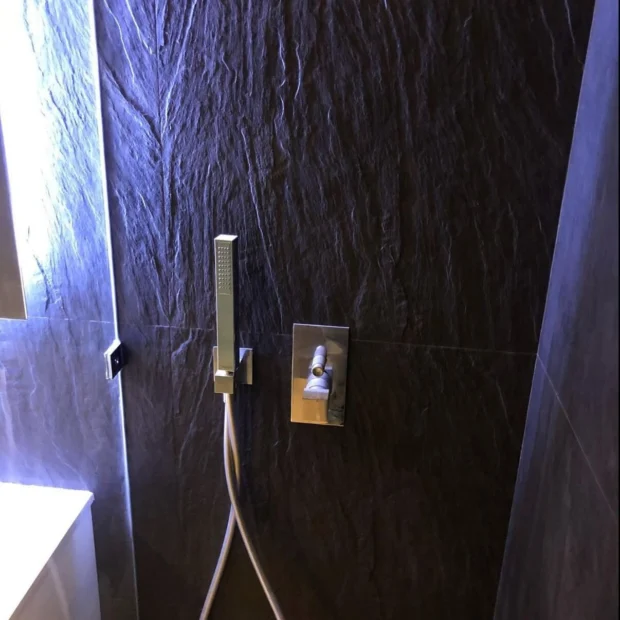 Duche com revestimento integral em pedra escura