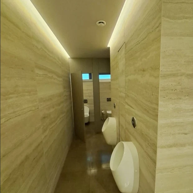 Corredor de acesso a sanitários, revestimento em travertino