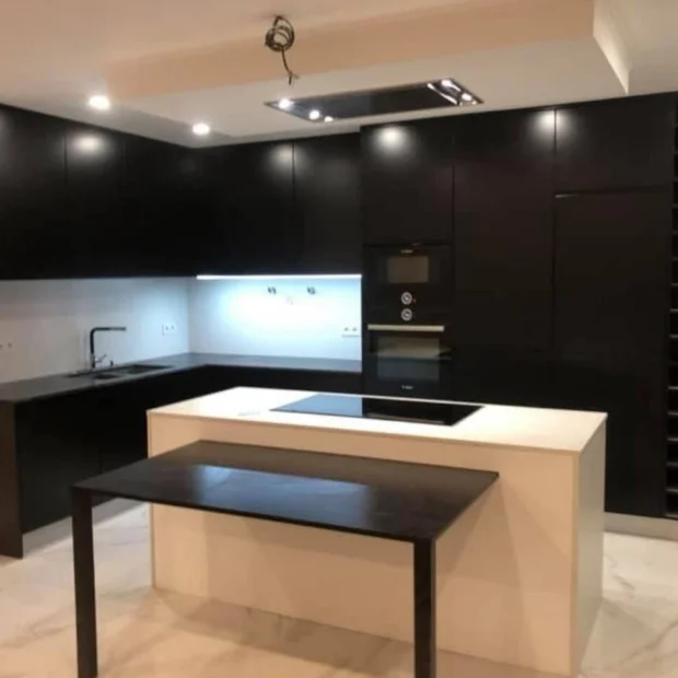 Cozinha lacada a preto com ilha e bancada em pedra