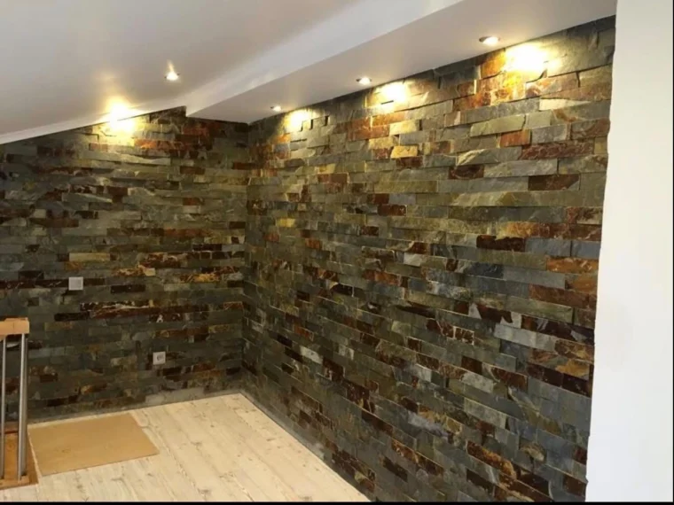 After — the same space with stone-clad walls and recessed lighting