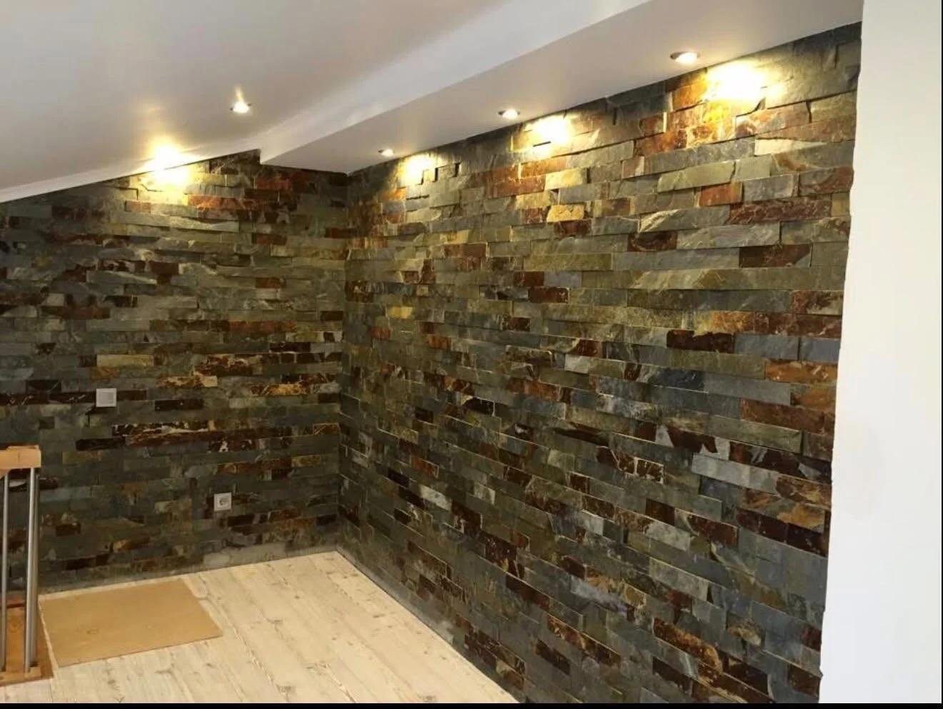 After — the same space with stone-clad walls and recessed lighting