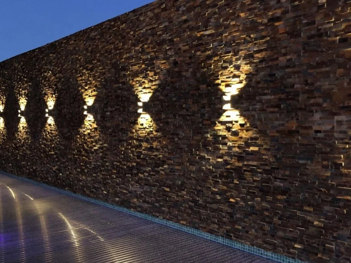 Depois — parede em pedra com iluminação rasante