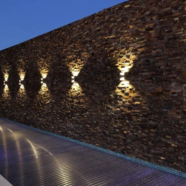 Depois — parede em pedra com iluminação rasante