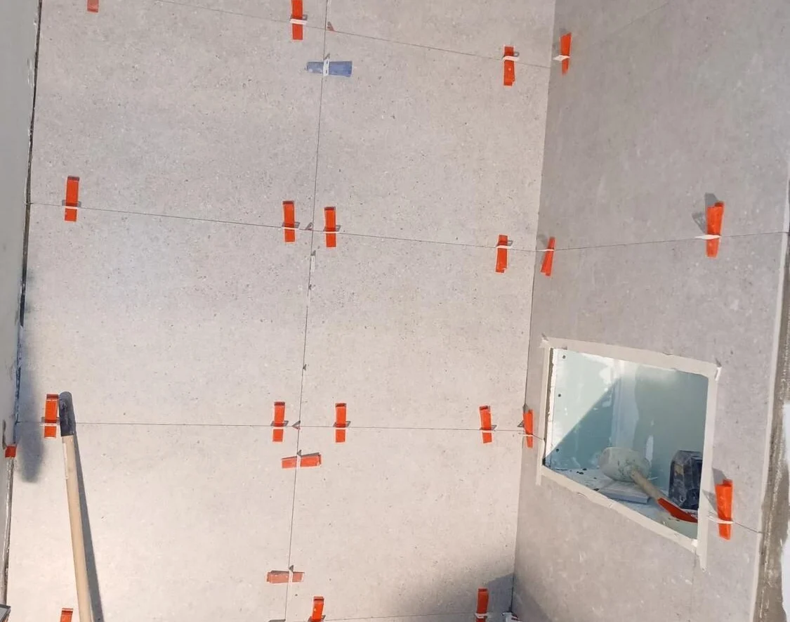 Laying tile with spacers and levelling clips