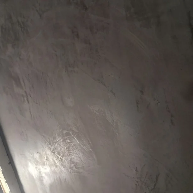 Parede em microcimento, com a textura contínua à vista