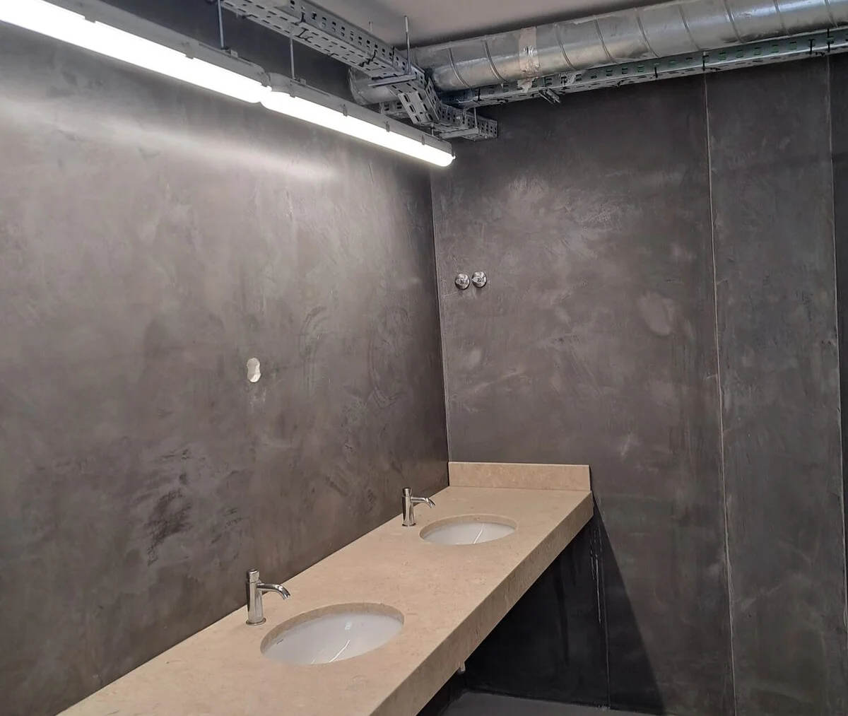 Run of microcement vanity with dark walls