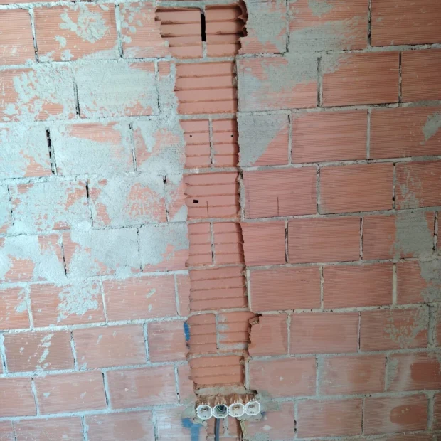 Roço vertical em parede de tijolo, já argamassado